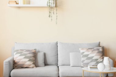 Işıl ışıl bir oturma odası rahat bir kanepesi ve rafı var.