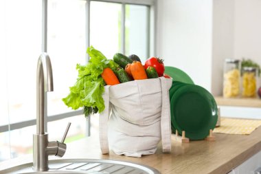 Mutfak lavabosunun yanında bir alışveriş çantası.