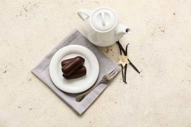 Beyaz grunge arka planda vanilyalı lezzetli süzme peynirli çay demliği ve tabak.