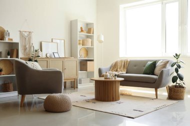 Koltuğu, koltuğu ve sehpası olan şık bir oturma odası.