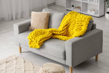 Modern oturma odası, şık gri kanepe ve sarı örülü ekose.