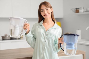 Mutfakta su filtresi olan genç bir kadın.