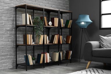 Kitaplığı, bitkileri ve parlayan lambası olan oturma odasının içinde.