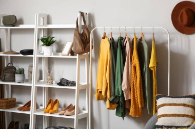 Giysileri ve rafları olan soyunma odasının içinde.