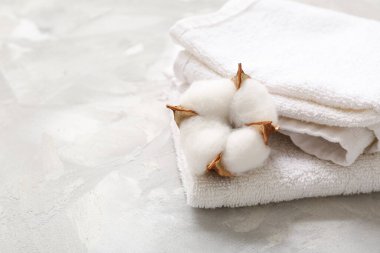 Gri arka planda temiz havlular ve pamuk çiçeği
