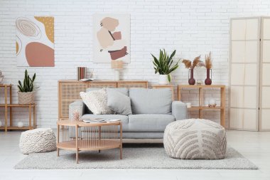 Rahat bir kanepe, kahve masası ve oturma odasının içi puf puf dolu.