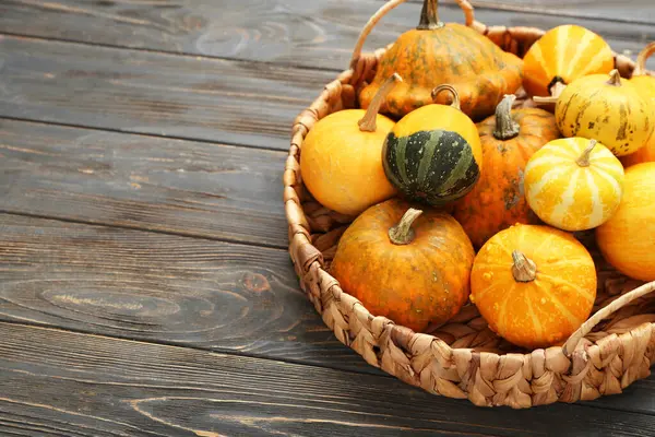 Gri ahşap arka planda taze balkabakları olan sepet.