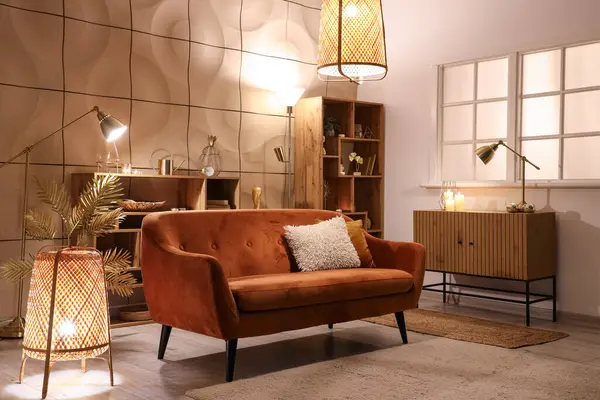 Parlayan lambalar ve gece kanepesi olan şık bir oturma odası.