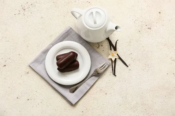 Beyaz grunge arka planda vanilyalı lezzetli süzme peynirli çay demliği ve tabak.