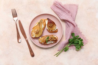 Bej arka planda ricotta peynirli ve cevizli armut bruschetta tabağı.