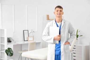 Klinikte dizüstü bilgisayarı olan bir erkek stajyer.