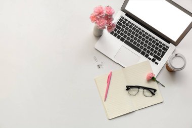 Modern dizüstü bilgisayarlı, gözlüklü, beyaz masadaki güzel çiçekli, üst manzaralı.