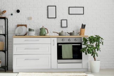 Mutfağın içi tezgah, fırın ve çatal bıçaklarla dolu.