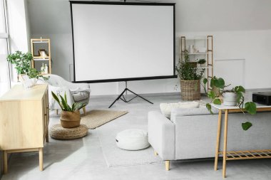 Boş projektör ekran, kanepe ve bitkilerle aydınlatma odasının içi