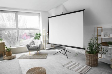 Boş projektör ekran, koltuk ve bitkilerle aydınlatma odasının içi