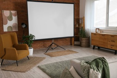 Boş projektör ekran, koltuk ve raf ünitesi olan odanın içi