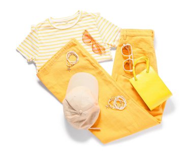 Beyaz arka planda takıları ve aksesuarları olan şık bir kadın bahar elbisesi.