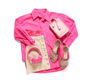 Beyaz arka planda aksesuarları ve kulaklıkları olan şık bir kadın bahar kıyafeti.