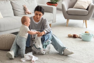 Genç anne doğum sonrası depresyondan muzdarip. Kirli çamaşırları ve bebeği evde.