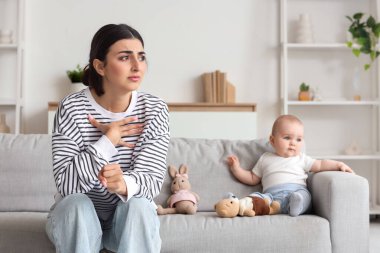 Genç anne doğum sonrası depresyondan muzdarip. Bebeği evde, kanepede yatıyor.