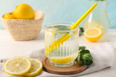 Lezzetli limonata, peçete ve tepsi beyaz ahşap masada, yakın plan.