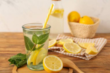 Ahşap masanın üzerinde bir bardak limonata ve malzemeyle kompozisyon, yakın plan.