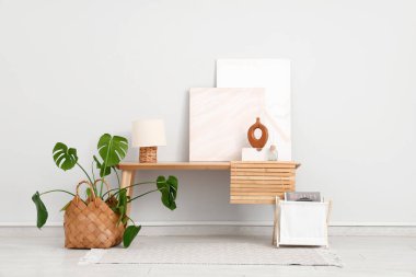 İçinde bank, resim ve Monstera bitkisi olan modern bir oda.