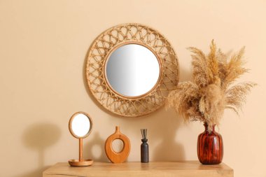 Vazolar masada ve yuvarlak aynada bej duvarda, yakın plan