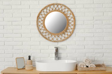 Banyodaki beyaz tuğla duvarda lavabo ve ayna olan çekmeceler, yakın plan.