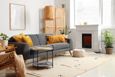 Oturma odasının içinde şömine, masa ve kanepe var.