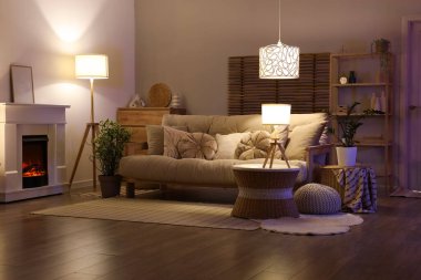 Karanlık oturma odasının içi şömineli, kanepeli ve masalı.