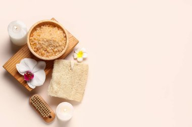 Bir kase deniz tuzu, spa aksesuarları ve renkli arka planda yanan mumlarla kompozisyon