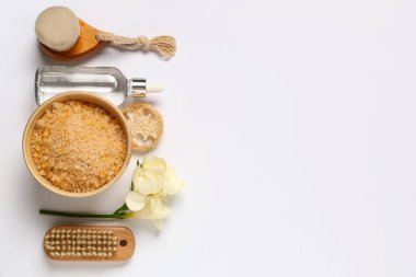 Deniz tuzu, masaj fırçası ve açık arkaplanda güzel çiçekler içeren kompozisyon