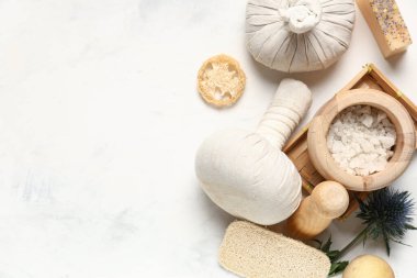 Spa aksesuarları ve hafif arka planda bir kase deniz tuzu içeren kompozisyon