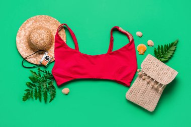 Yeşil arka planda mayo, çanta ve şapka ile yaz kompozisyonu, yakın plan