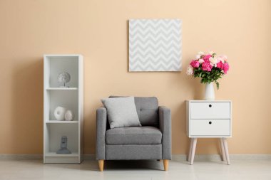 Çekmece, koltuk ve vazo. Oturma odasının iç tarafında güzel şakayık çiçekleri var.