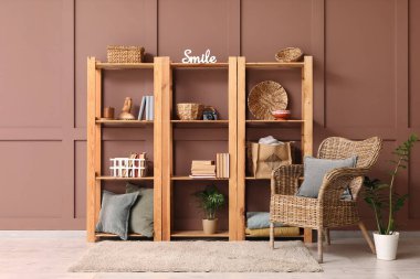 Odanın içinde ahşap raf ünitesi ve koltuk var.