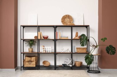 Kitaplı siyah raf ünitesi, şık dekorasyon ve odada palmiye bitkileri