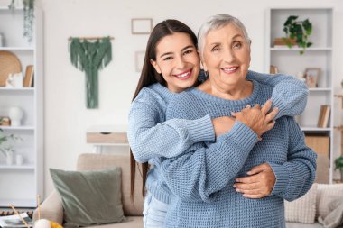 Mutlu genç bir kadın büyükannesine sarılıyor.