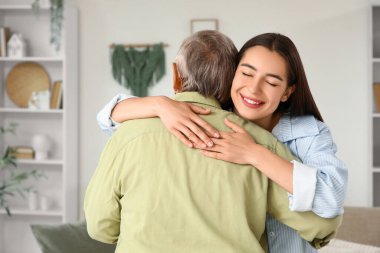 Mutlu genç bir kadın büyükannesine sarılıyor.