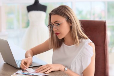 Ofiste renk paletleriyle çalışan kadın düğün planlamacısı