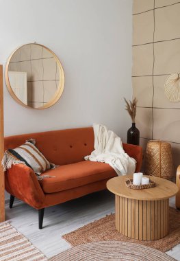 Kahverengi kanepesi, aynası ve kahve masası olan oturma odasının içinde.