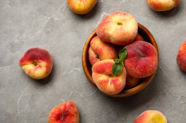 Tatlı incir şeftalili kase ve gri arka planda nane şekeri.