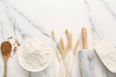 Kasede buğday unu, yuvarlanan iğne ve çiviler beyaz masada.