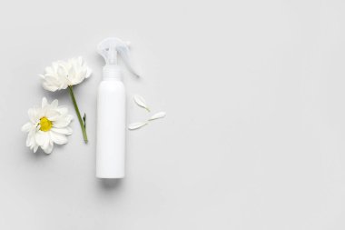 Kozmetik ürün şişesi ve açık arkaplanda güzel papatya çiçekleri olan kompozisyon