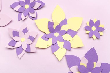 Mor arkaplanda renkli origami çiçekleri