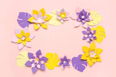 Renkli origami çiçeklerinden yapılmış çerçeve pembe arkaplanda yapraklarla