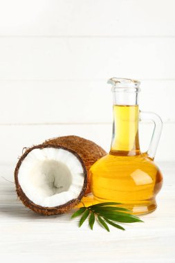 Beyaz ahşap arka planda hindistan cevizi kozmetik yağı dekanı