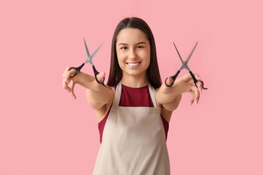 Pembe arka planda makaslı kadın kuaför.