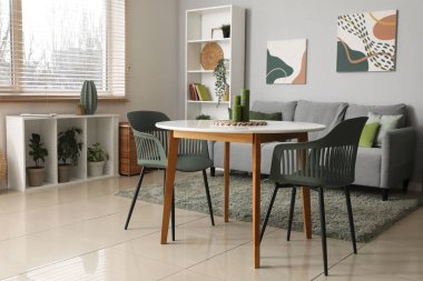 Kanepesi, masası ve raf ünitesi olan şık bir oturma odası.